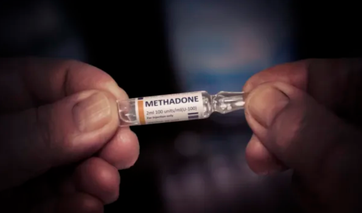 image of someone holding a methadone bottle